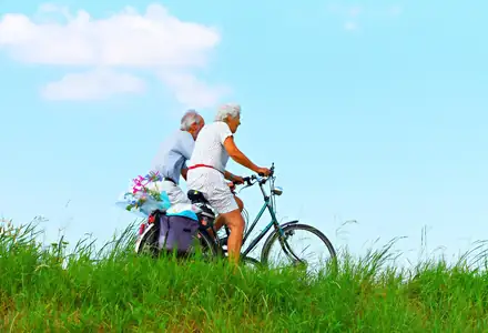Older couple cycling together on a sunny day